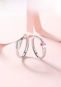 Detail of S925 silver couple rings with pink heart zircon and elegant twisted design