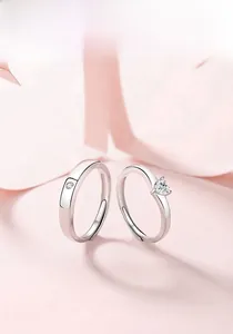 Close-up of heart-shaped diamond silver ring set with adjustable open band for couples