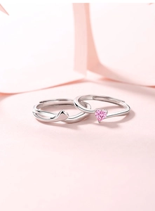 Dettaglio di anelli di coppia in argento S925 con pietra a cuore rosa e design avvolgente