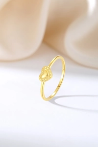 Détail d'une bague cœur en or avec finition polie et poinçon S925 sur tissu