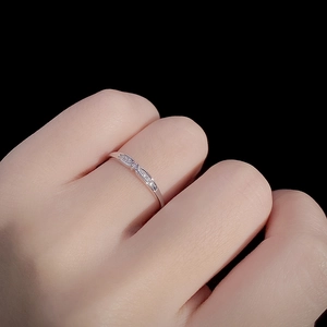 Bague nœud argentée élégante avec pierres pavées portée sur main avec fond noir profond