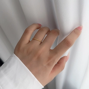 Minimalist S925 sterling silver twisted rope ring in gold finish worn on middle finger