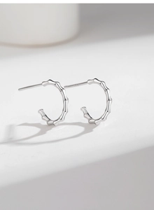 Close-up of S925 sterling silver bamboo joint earrings with smooth metallic texture