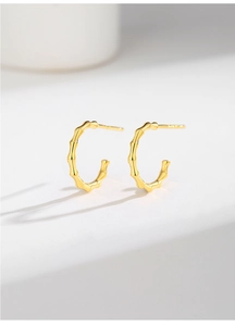 Detailed macro view of S925 sterling silver bamboo-joint C-shaped stud earrings in 18K gold finish