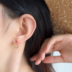 Elegant gold textured hoop earrings with beaded bamboo design shown on female model