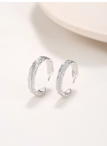 Close-up of S925 silver feather couple rings with detailed engraving and pavé zircon stones