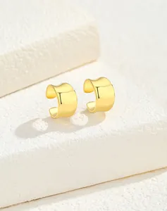 Close-up of golden S925 silver C-shaped ear cuff with polished irregular concave surface