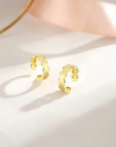 Détail d'un ear cuff S925 argent à motif nid d'abeille avec finition dorée