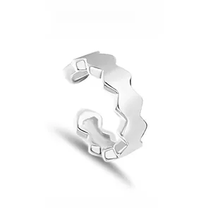 Détail macro d'un earcuff alvéolé en argent avec un design minimaliste poli en forme de C