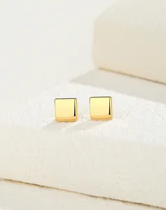 Macro view of minimalist S925 silver square stud earrings with polished gold finish