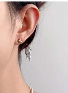 Close-up of minimalist gold square stud earring with a polished mirror finish on the earlobe