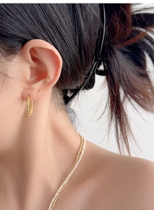 Close-up of minimalist gold U-shape S925 silver earrings on female model's ear