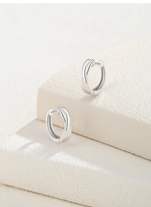 Polished S925 sterling silver crossover knot hoop earrings on a marble stone surface