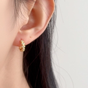 Elegant gold S925 sterling silver hoop earrings with round zircons worn by a female model