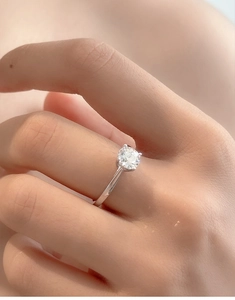 Close-up of a classic six-prong round moissanite ring worn on a finger for a minimalist look