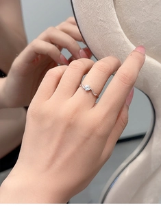 Detailed view of an S925 silver wave ring with 0.3CT moissanite on a finger