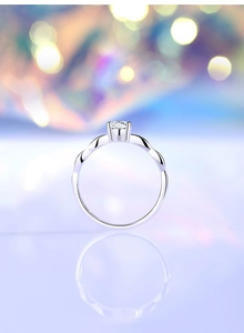 Nahaufnahme eines klassischen Sechs-Klauen-Moissanit-Rings mit gedrehtem Silberband und Bokeh