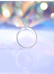 Macro view of a classic six-prong round solitaire ring with a polished silver finish
