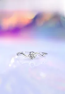 Macro shot of S925 silver wave ring with 0.3CT moissanite stone and bokeh background