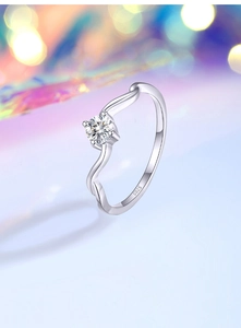 Macro detail of wave-shaped S925 silver ring featuring a bright round moissanite stone