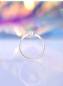 Macro shot of 925 silver moissanite ring with six-prong setting and wave band detail