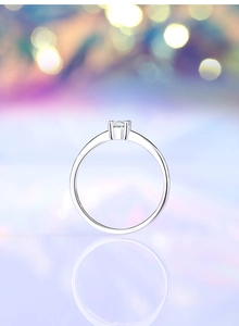 Macro detail of classic four-prong silver ring with a round brilliant-cut moissanite stone