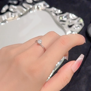 Elegant S925 silver four-prong moissanite ring with minimalist twisted band on finger