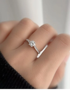Macro shot of a 0.5ct moissanite ring with four-prong setting on a hand