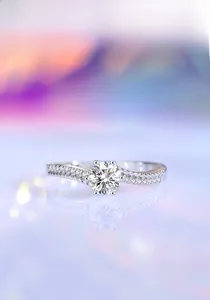 Macro detail of six-prong moissanite ring with wavy diamond-set band and reflection