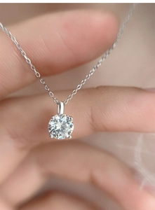 Macro shot of 5mm moissanite pendant featuring 925 silver four-prong setting and fine chain