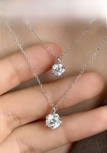 Macro shot of two S925 sterling silver necklaces with six-prong moissanite pendants