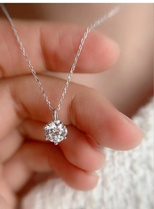 Macro shot of 1ct moissanite pendant with classic six-prong setting on silver chain