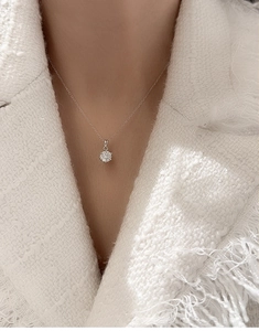 Close-up of S925 silver necklace with 1ct round moissanite pendant in six-prong setting