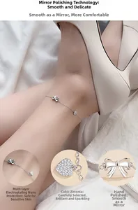 Detail of silver anklet with heart and bow charms featuring cubic zirconia inlays