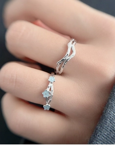 Macro view of S925 sterling silver branch rings with light blue floral enamel detail