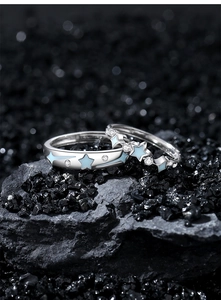 Macro shot of S925 sterling silver couple rings with blue star enamel on black stones