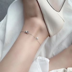 Elegant S925 sterling silver anklet with bow and sparkling heart charm on a woman's ankle