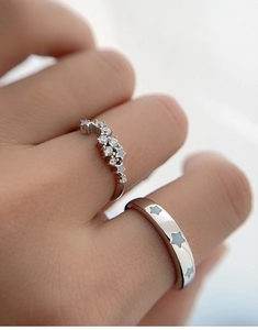 Detail of S925 sterling silver couple rings with tiny star icons and pavé set crystals