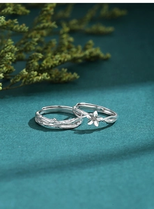 Dettaglio di anelli per coppia in argento S925 con design a fiore e trama di corteccia