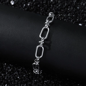 Bracelet chaîne à maillons ovales en acier poli pour homme sur support noir