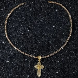 Macro d'un pendentif croix hip hop en or avec zircones sur fond de sable noir élégant