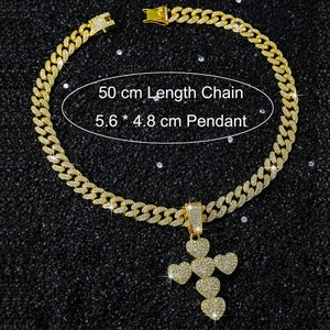 Macro shot of 50cm gold iced out Cuban chain with heart-shaped cross pendant on black rocks