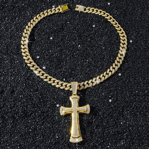 Macro view of gold-plated iced-out cross pendant and cuban chain with sparkling zircons
