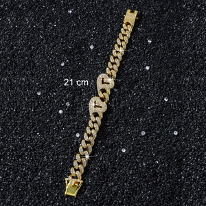 Detail eines 21 cm langen goldfarbenen Panzerarmbands mit BABY-Anhänger und Steinen