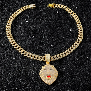 Vue détaillée du pendentif tête de lion doré serti de cristaux sur une chaîne cubaine