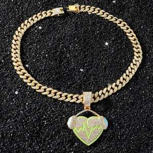 Détail du collier à chaîne cubaine avec pendentif coeur à battement vert
