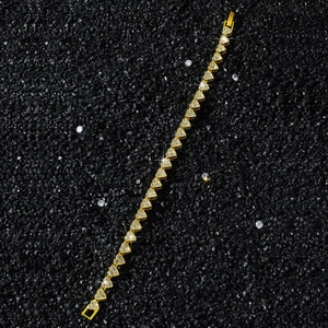 Gros plan d'un bracelet de tennis doré avec maillons en forme de cœur et zircons brillants