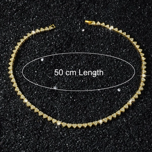 Vue macro d'un collier chaîne à cœurs dorés de 50 cm avec des zircons blancs brillants