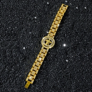 Macro shot of gold iced-out hip hop watch band bracelet with rotating cross on black stones