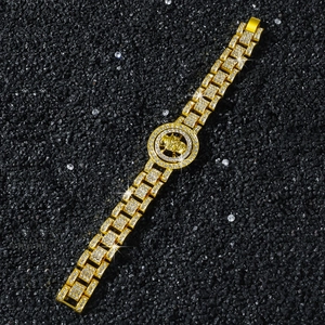 Détail macro du bracelet doré style hip-hop avec emblème tête de mort rotatif et cristaux pavés